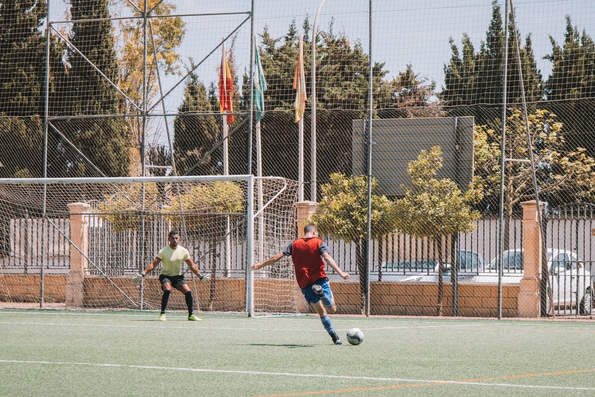 Two men playing soccer on a soccer pitch